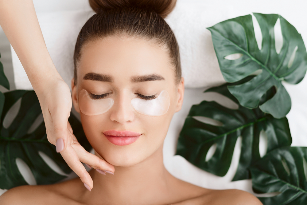 Woman,With,Eye,Patches,,Relaxing,In,Spa,Center,With,Leaves